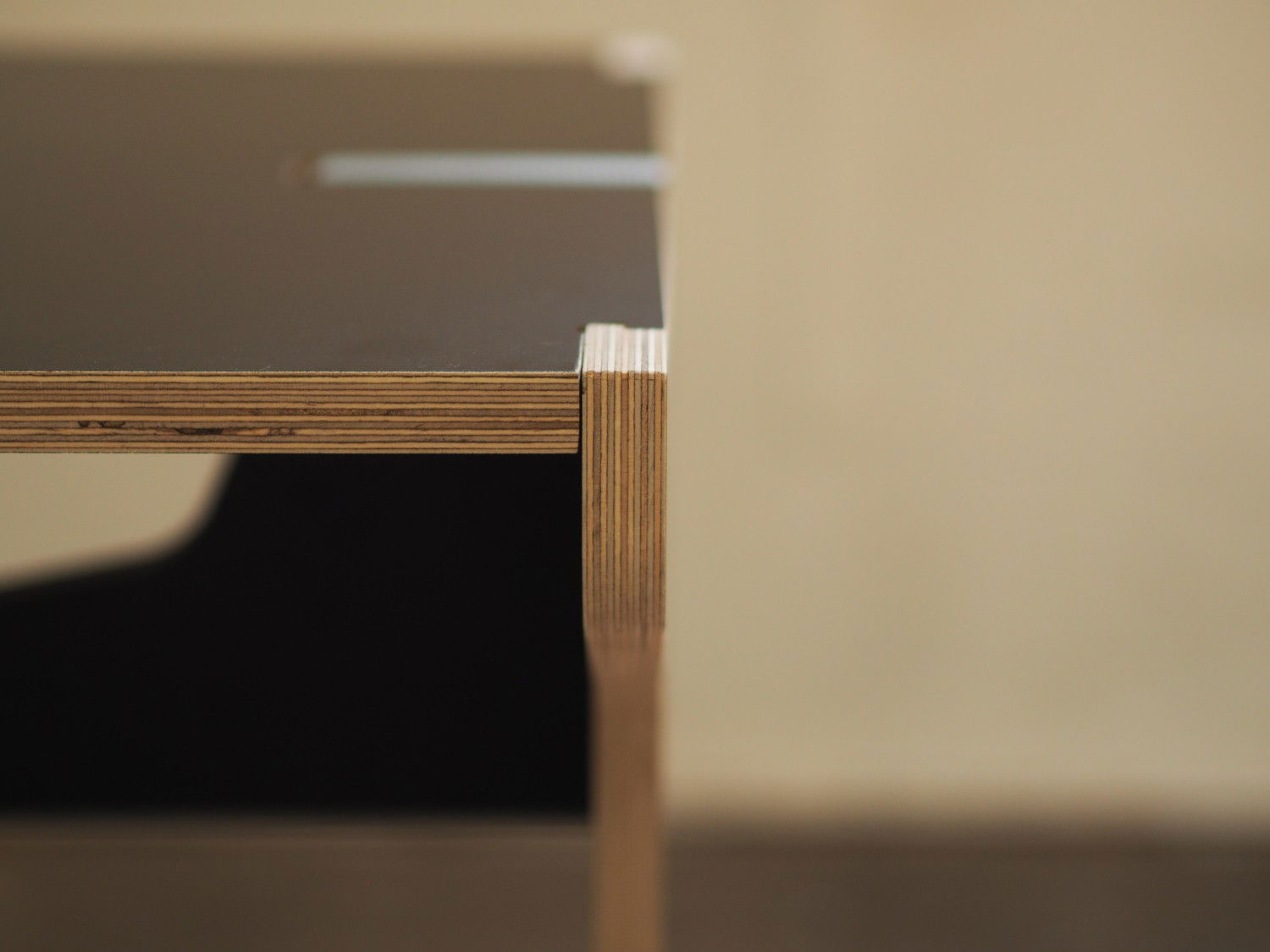 Frontal detail shot of the Pinza Table where the flank of the leg locks into the tabletop.